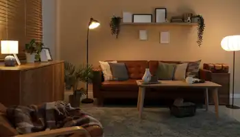 Interior Of Dark Living Room With Glowing Lamps, Sofa And Shelf At Night