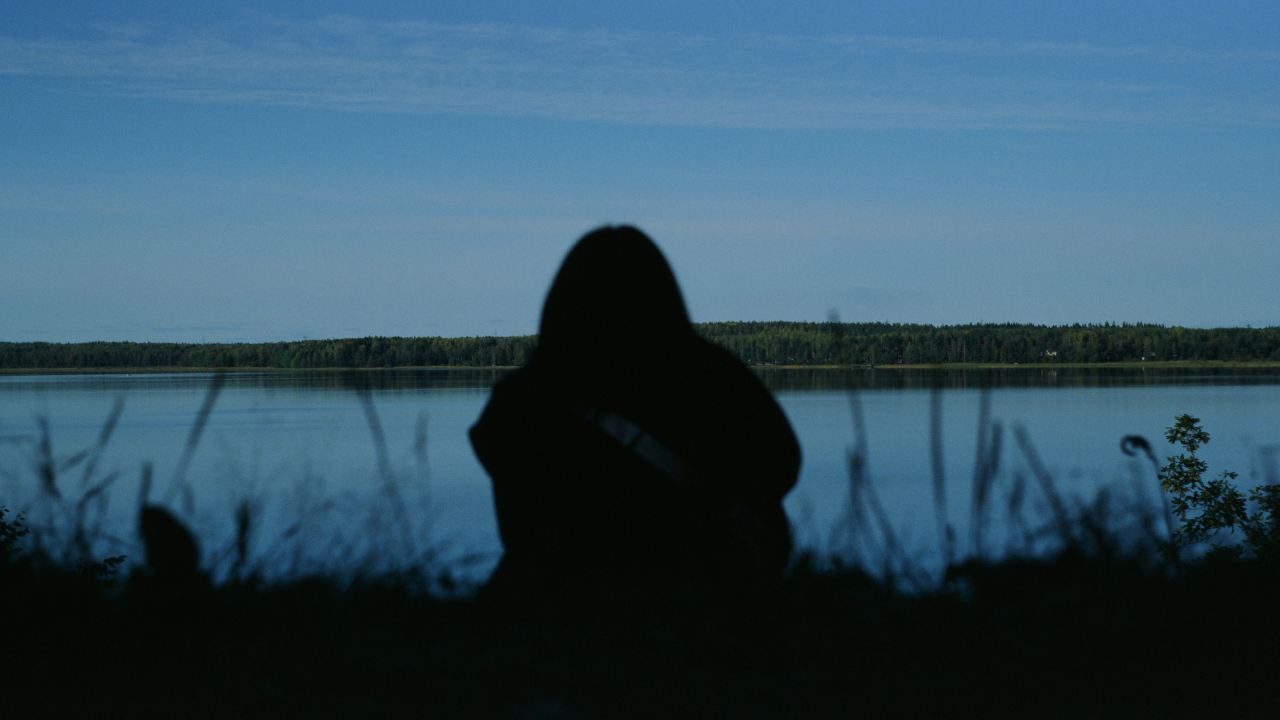 Person Sitting Near Lake