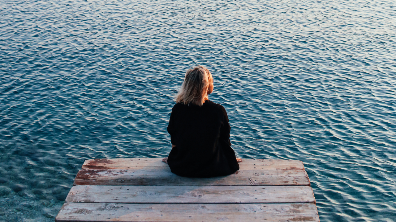 A Person Sitting Alone On Dock